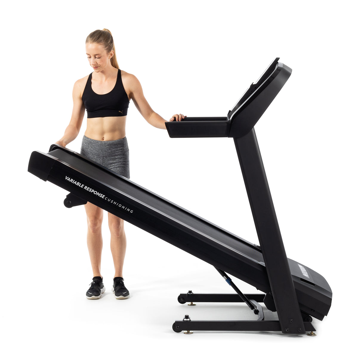 Horizon T101 Treadmill being folded by a woman