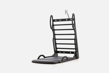 Open stretch station in black wood with horizontal rungs and a dark fold-out mat