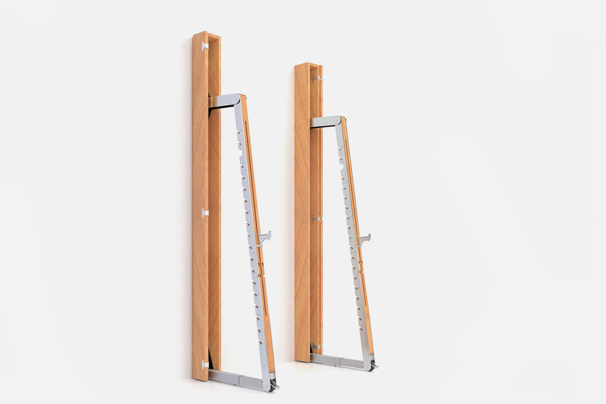 Two wall-mounted squat racks in warm golden wood, one folded shut and one opened to a silver ladder