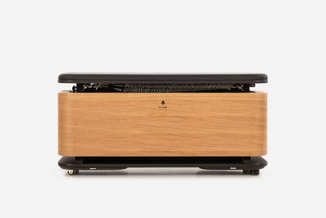 Front view of a pale oak storage bench with the padded lid raised and resistance bands visible inside